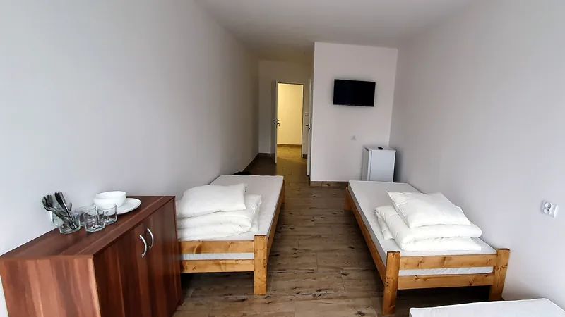 Hotel pracowniczy Warszawa: jasny pokój w hotelu pracowniczym w Warszawie, łóżka z białą pościelą