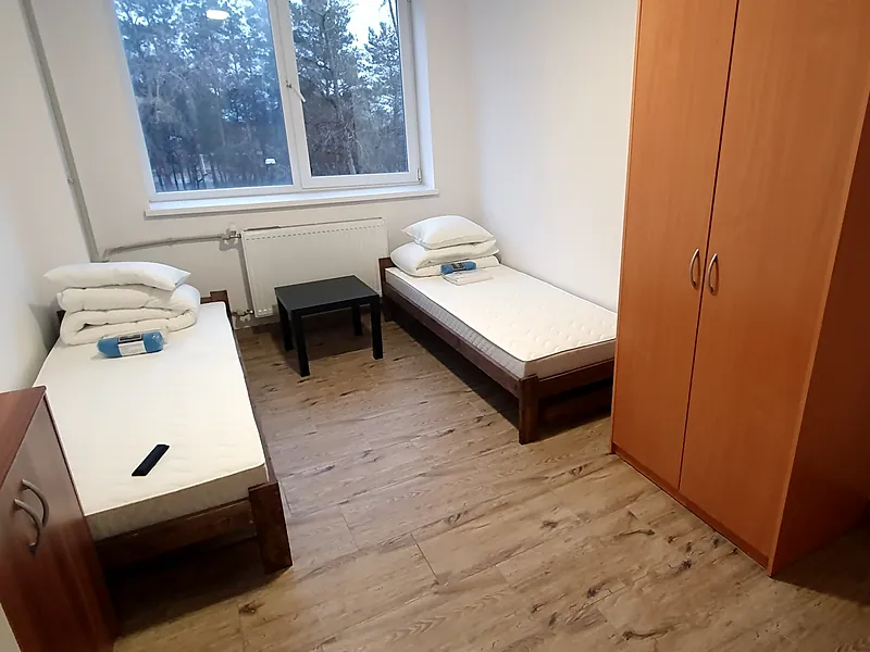 Pokój 2-osobowy na dłuższy pobyt: pokój dwuosobowy z oknem na drzewa, dwoma łóżkami, stolikiem i dużą szafą